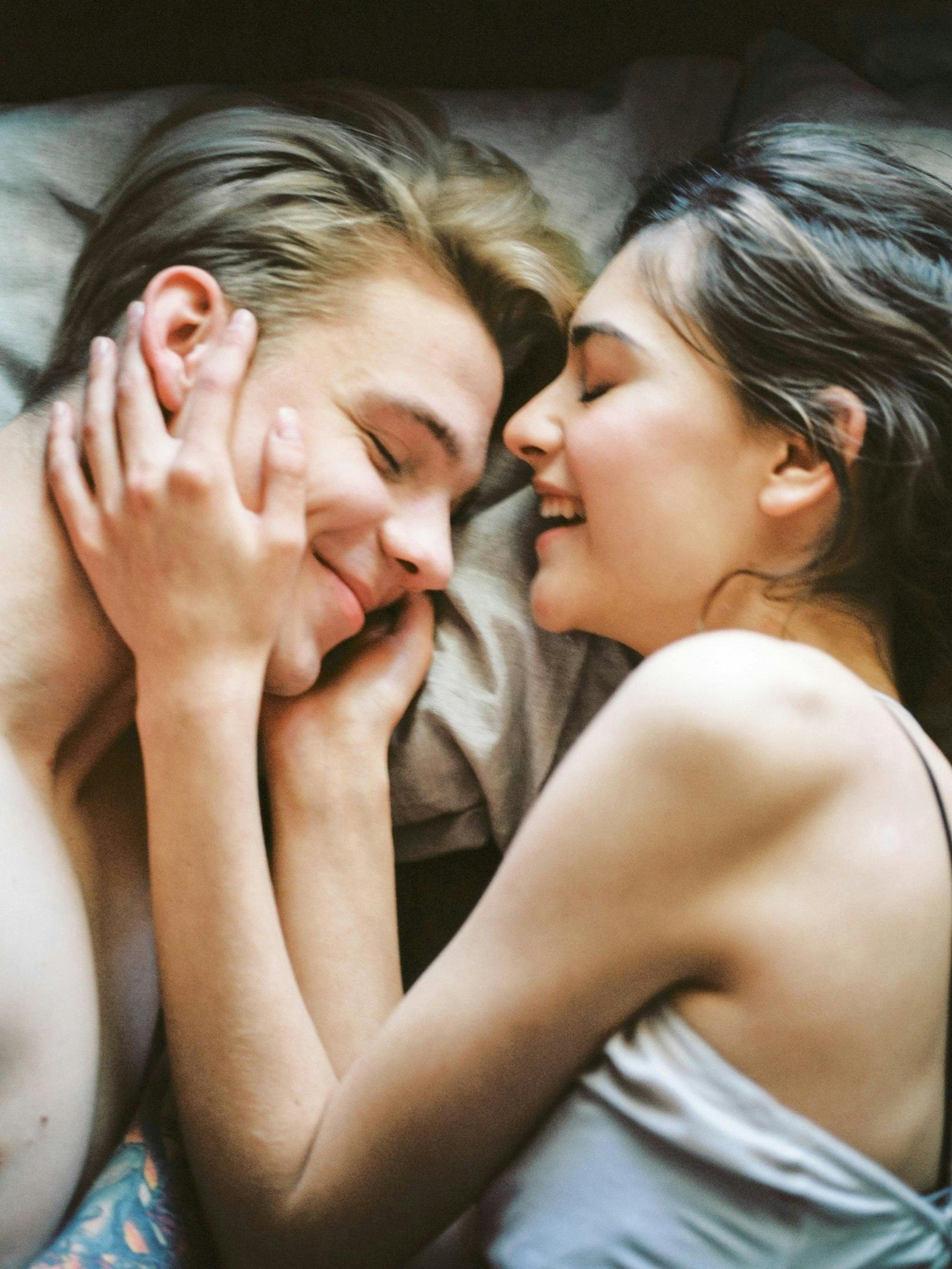 Vibromasseur en couple conseils - couple souriant dans un lit partageant un moment intime